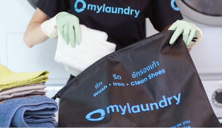 mylaundry staff putting clean clothes into a hygienic laundry bag