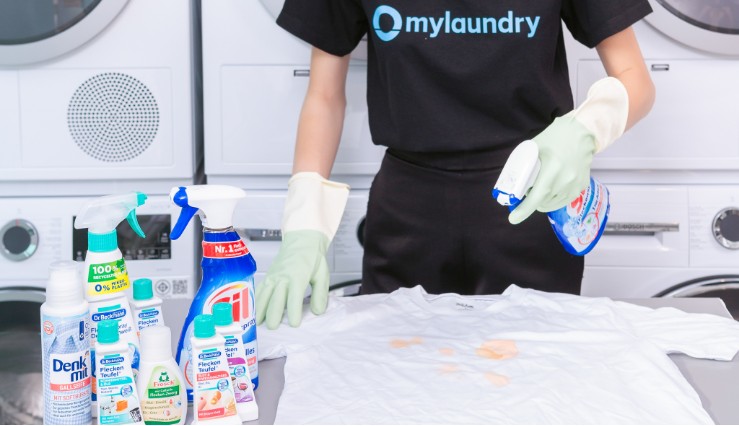 Staff member spraying clothes as a laundry pretreatment